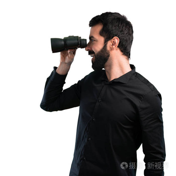 英俊的人与胡子用双筒望远镜在白色背景