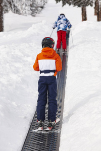 孩子们开始学习如何滑雪。冬季运动