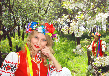 在民族服装中开花春天的花园中的乌克兰姑娘