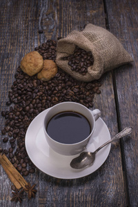 咖啡在一杯, 咖啡豆, 香料 肉桂, 豆蔻, 茴香, 饼干的形状的心在木质的背景。顶部视图