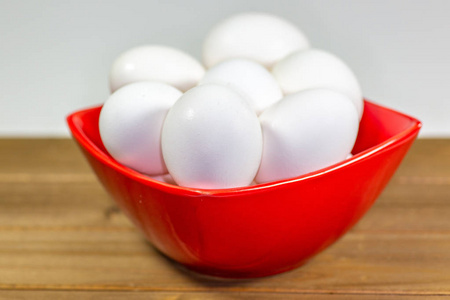 一组鸡蛋在一个深红色的碗里等待厨师在一餐中使用它们