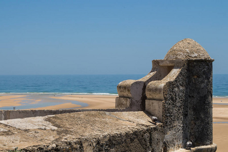 由石头制成的旧堡垒塔。在涨潮后, 在沙滩上看到水坑。大西洋地平线。蓝天。Cacela Velha, 阿尔加维, 葡萄牙