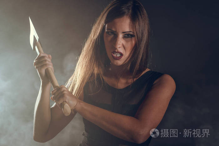 危险的女人与生锈的斧头在黑暗的烟雾室