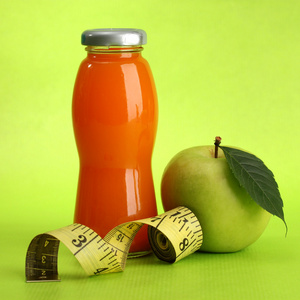 瓶果汁 苹果和卷尺，绿色背景