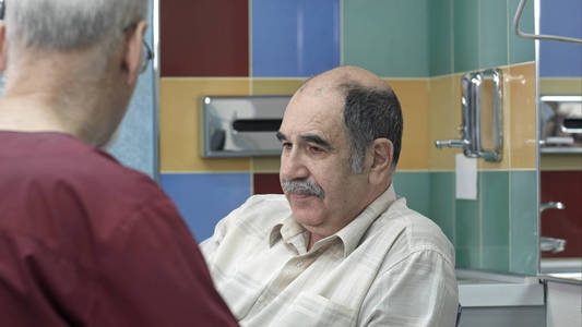 高级男医生在手术中与老人交谈