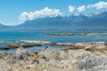 美丽的海滩岩石在凯库拉与山背景, 新西兰自然风景背景