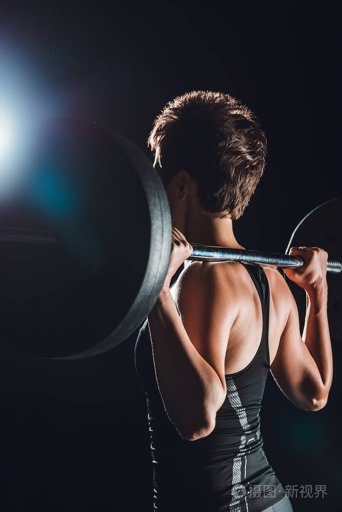 运动员运动与杠铃, 黑色背景的侧面视图