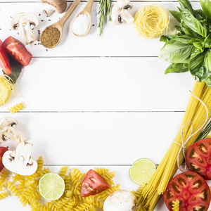 烹调用的食物-面食, 罗勒, 蔬菜, 石灰和香料在一个圆的形状白色木桌.