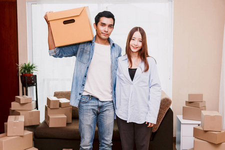 年轻夫妇与纸板盒在家里企业在线和交付概念