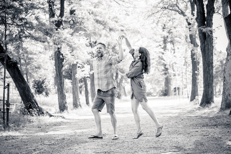 快乐的情侣在一个美丽的绿色公园里跳舞, 一起玩得开心。