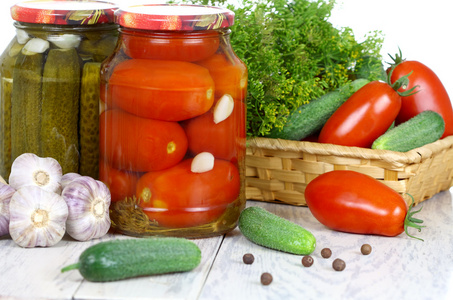 罐头和新鲜的西红柿和黄瓜，香料在木桌子上