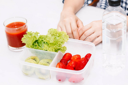 在厨房里吃水果和蔬菜的女人健康的生活方式概念