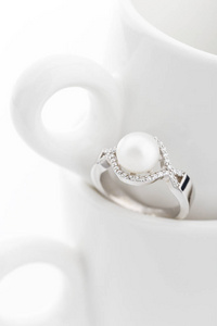 白色背景的大珍珠和钻石银戒指