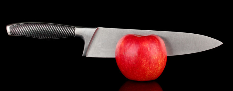 红苹果和孤立的黑刀图片