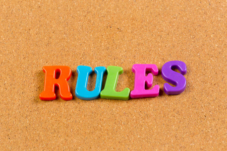 软木背景上彩色玩具字母字母的单词规则
