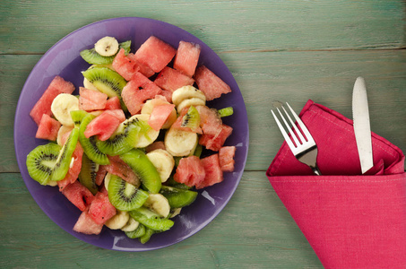 盘上木制背景健康的新鲜水果沙拉