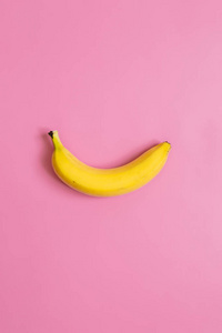 一个, 单香蕉在粉红色的垂直背景。文本空间。简约理念