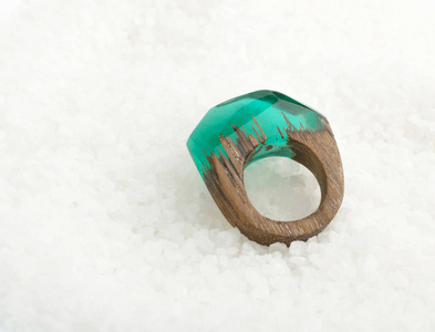 绿色圆环由木头和树脂制成。白色水晶背景手工首饰