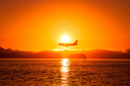 日落时飞机低空飞越水面