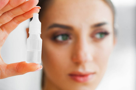 小女孩手里拿着眼药水.一个戴隐形眼镜的漂亮女人的肖像.健康的外观.