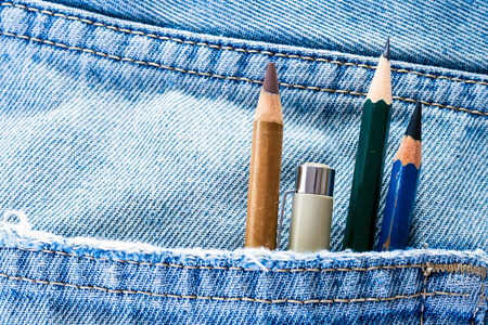 铅笔和钢笔在牛仔布蓝色牛仔的口袋里