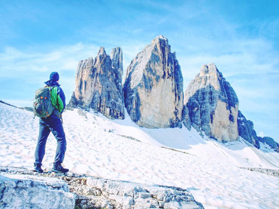 在阳光明媚的绕, 背包客在旅途中 Cime Lavaredo。观看从游览在普遍的巨型, 白云岩阿尔卑斯, 意大利