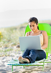 女人在海滩上使用便携式计算机