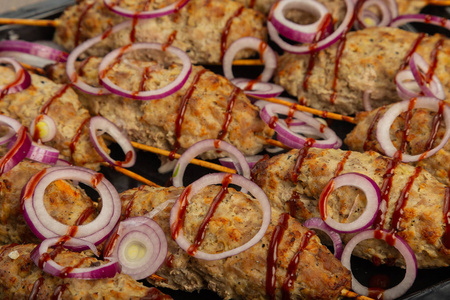 Lulya 烤肉串羊肉串烤肉串在棍子, 剁碎的肉。传统的高加索菜。在砧板上, 用绿色沙拉番茄酱香料