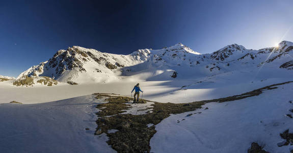 日落时分, 一个人站在雪山上的悬崖上