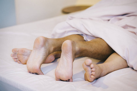 在床上关闭男性和女性的脚