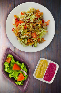 鸡肉沙拉配蔬菜 胡萝卜, 洋葱, 辣椒, 卷心菜, 西红柿, 花椰菜。木制背景下的鸡肉沙拉