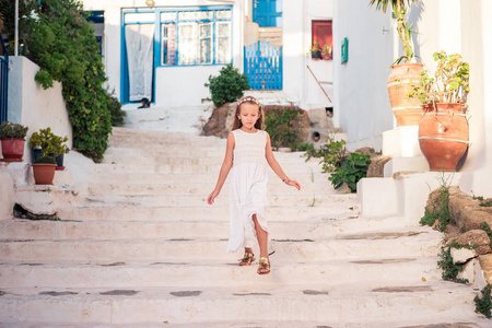 儿童在典型的希腊传统村庄的街道与白色墙壁和五颜六色的门在米科诺斯岛