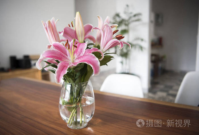 花束粉红色百合花在玻璃花瓶在木桌在房间里照片 正版商用图片05ro65 摄图新视界