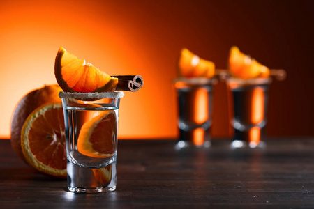 一杯木制的橙色和肉桂棒龙舌兰酒