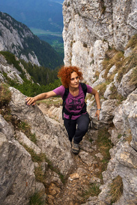 妇女自由攀登在一个通过 ferrata 在落基山脉