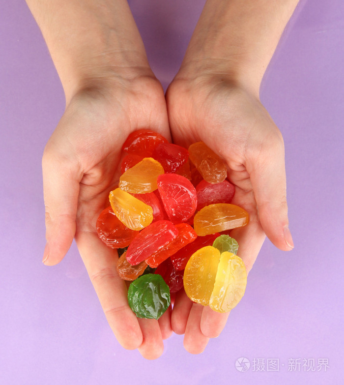 手里的糖果紫色背景上