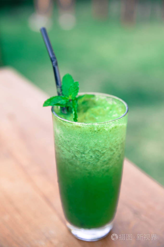 绿色新鲜的冰沙.在木质背景下排毒夏日饮品