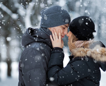 愉快的情侣亲吻在冬天公园图片