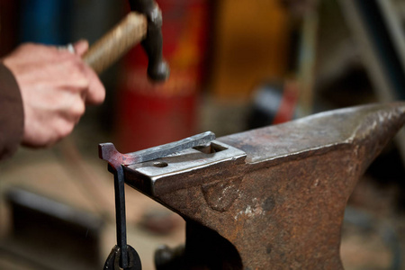 一个铁匠手操纵金属片在他的锻造, 选择性焦点的特写
