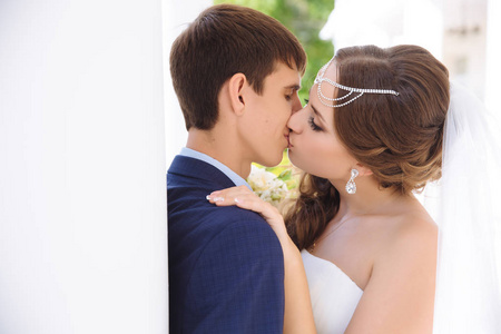 亲密的新婚夫妇亲吻在他们的婚礼当天在希腊风格的嘴唇轻轻