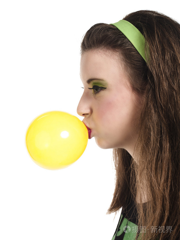 一名年轻女子吹泡泡糖的侧视图