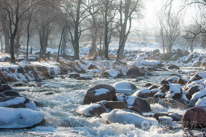 在早春流在一条小河的水春景山风景用冰冻的小溪