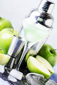 酒精鸡尾酒与绿色苹果和干苦艾酒, 糖浆, 柠檬汁和冰块。条形工具, 灰色石材背景, 选择性聚焦
