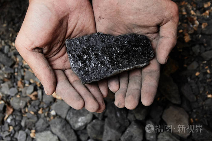 煤矿矿工在人手中的煤炭背景煤炭开采或能源环保工业煤岩