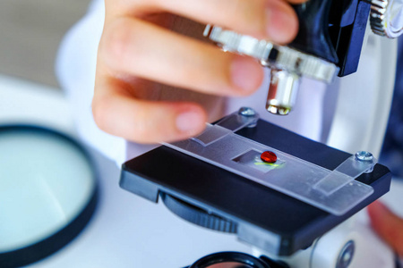 近距离科学家手里的女人用显微镜, 血液测试分析