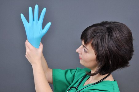 医生穿上蓝色灭菌医用手套，使操作