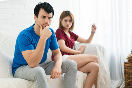 失意的丈夫坐在妻子身旁, 看着老婆手里的怀孕考试。早上不是好消息
