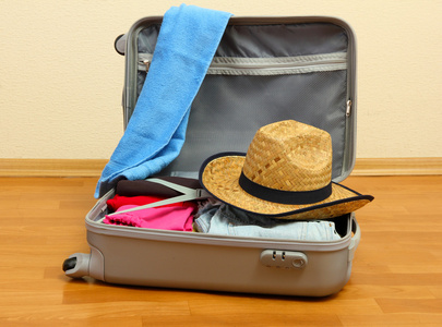 用在房间里衣服打开银色手提箱照片