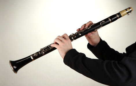 灰色背景上单簧管演奏的音乐家照片