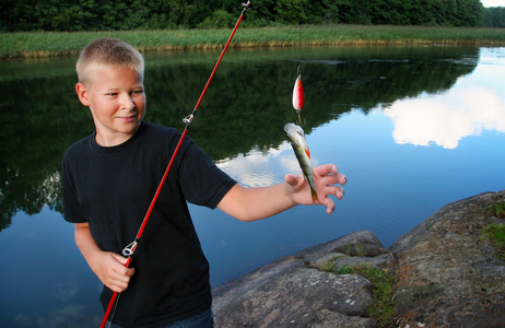 男孩抱着他的渔获的一天图片